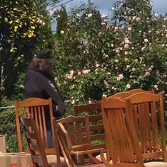 a man standing on top of a wooden deck next to two chairs and a table