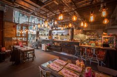 a restaurant with lots of lights hanging from the ceiling and tables in front of it