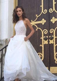 a woman in a white dress is standing on the steps near a door and wearing heels