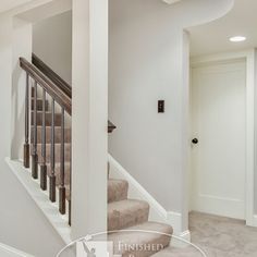 an empty living room with stairs and carpet