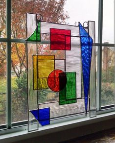 a colorful glass sculpture sitting on top of a window sill