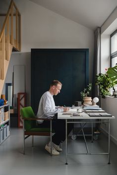 a man sitting at a desk working on his laptop