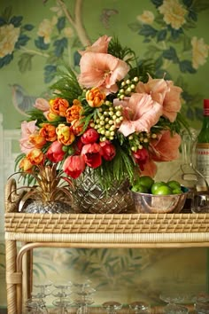 a vase filled with flowers sitting on top of a table next to a bottle of wine