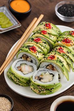 sushi rolls on a plate with chopsticks next to it and dipping sauce