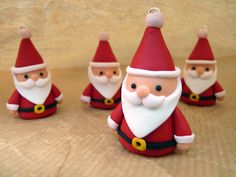 four santa clause figurines sitting next to each other