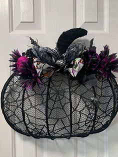 a black mesh bag with purple flowers on the front and side, attached to a door