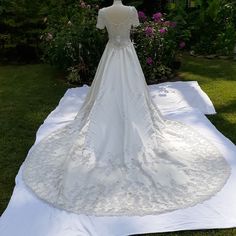 a white wedding dress on display in the grass