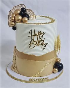 a birthday cake decorated with gold and black decorations