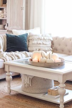 a white coffee table with candles on it