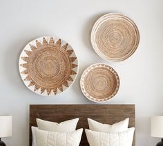 a bed with two baskets on the wall above it, and another set of pillows