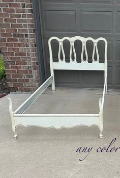 a white bed frame sitting in front of a garage door