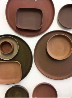 brown and green plates are arranged on a white surface