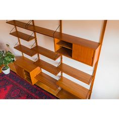 a wooden shelf with shelves on top of it and a potted plant next to it