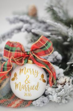 a christmas ornament with a red and green plaid bow on it next to pine cones