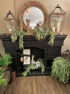 a fireplace decorated with greenery and candles for the holiday season is displayed in front of a mirror