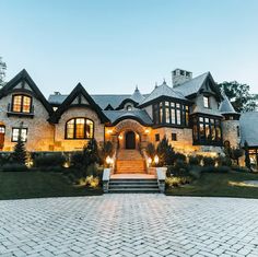 a large house with lots of windows and steps leading to the front door at night