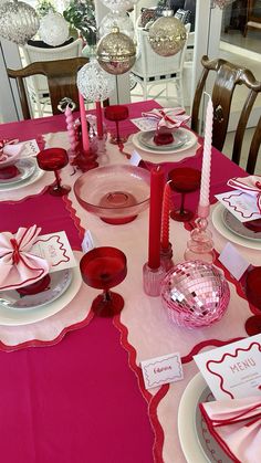 the table is set for valentine's day with pink and red decorations