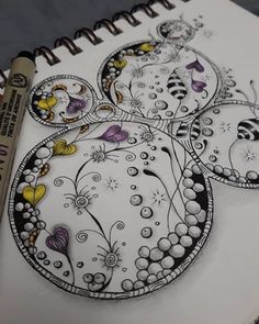 a coloring book with an image of flowers and butterflies on the cover, next to a marker