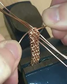 a person is working on some kind of piece of wire that they are holding in their hands