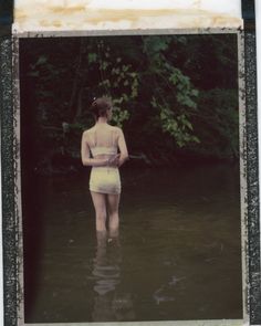 a woman standing in the water with her back to the camera