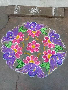 a colorful flower design is painted on the ground