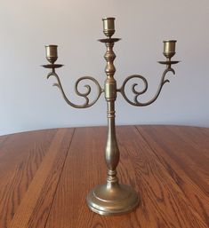 a metal candelabra sitting on top of a wooden table