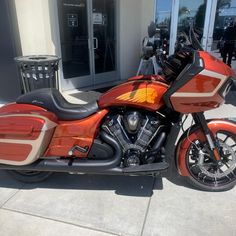 an orange motorcycle parked in front of a building