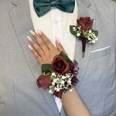 a man in a gray suit and bow tie with flowers on his lapel flower