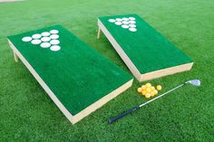 two book shaped cornhole game boards on grass with golf club and tees in the background