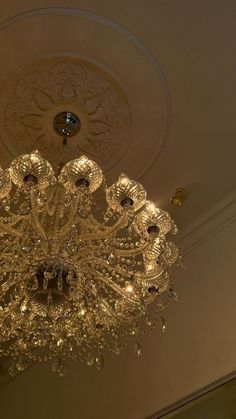 a chandelier hanging from the ceiling in a room with white walls and ceilings