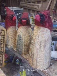 three wooden birds sitting on top of a piece of wood