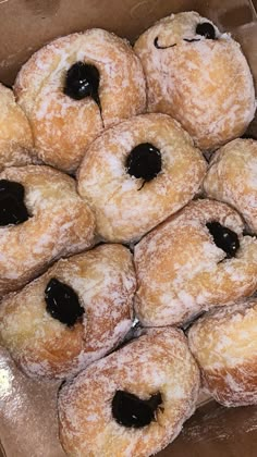 a bunch of doughnuts that are sitting in a cardboard box on the table