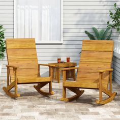 two wooden rocking chairs sitting on top of a patio next to a table and potted plant