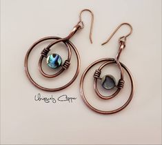 These copper earrings have been wire wrapped with an abalone shell bead in the in the center and have a drop length of 2 inches. They have been given an antiqued finish and then clear coated to protect them from tarnishing. They will make a perfect gift for her, as a 7th anniversary gift, copper anniversary, or 22nd anniversary gift. NOTE: These earrings are made to order, so please allow for slight variations in the center abalone shell bead. While they have been clear coated avoid water exposu Wire Jewelry Earrings, Wire Jewelry Patterns, Wire Wrapped Stone Jewelry, Stone Bead Jewelry, Wire Wrap Jewelry Designs, Wire Wrapped Jewelry Diy, Copper Anniversary, Wire Jewelry Designs, 7th Anniversary