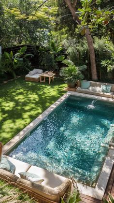 an outdoor swimming pool surrounded by greenery