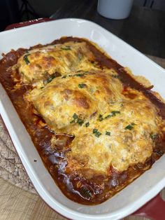 a casserole dish with meat, cheese and sauce in it on a table