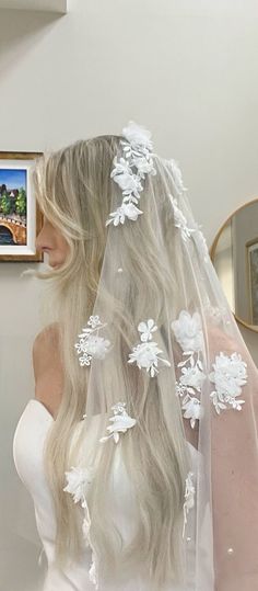 a woman wearing a white veil with flowers on it