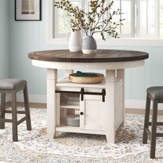 a kitchen table with two stools next to it