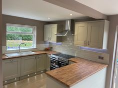 a kitchen with an oven, stove and sink next to a window in the room