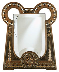 a mirror with an ornate design on the front and sides, sitting on a stand