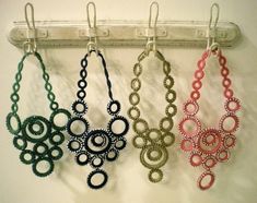 four pairs of earrings hanging from hooks