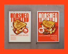 two posters on the side of a building advertising toasted sandwiches