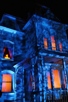 an old house with blue lights in the windows