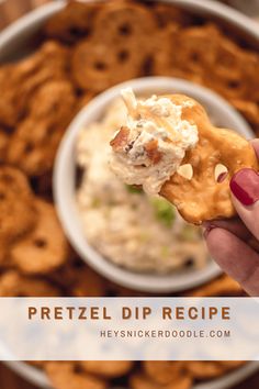 a hand holding a cracker over a bowl of dip and onion rings with the words pretzel dip recipe above it