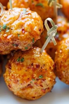 some meatballs with toothpicks on them are sitting on a white platter