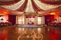 the dance floor is decorated with red and white drapes, draped curtains, and lights