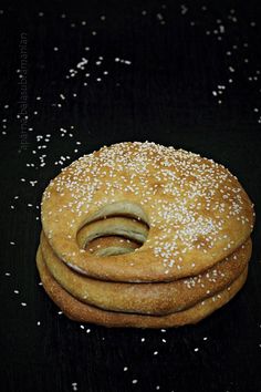 a stack of three round breads sitting on top of a black table covered in white sprinkles