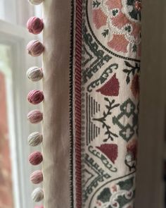 a close up of a curtain with tassels on the top and bottom of it