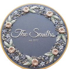 the smiths embroidery pattern is displayed in a hoop with flowers and leaves on it