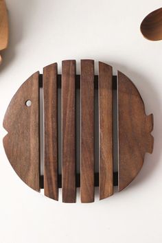 a fish shaped wooden object on a white surface